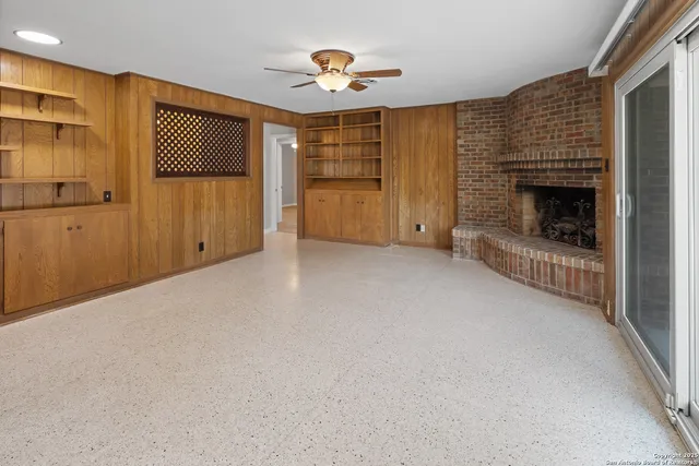 a view of an empty room with a fireplace and a window