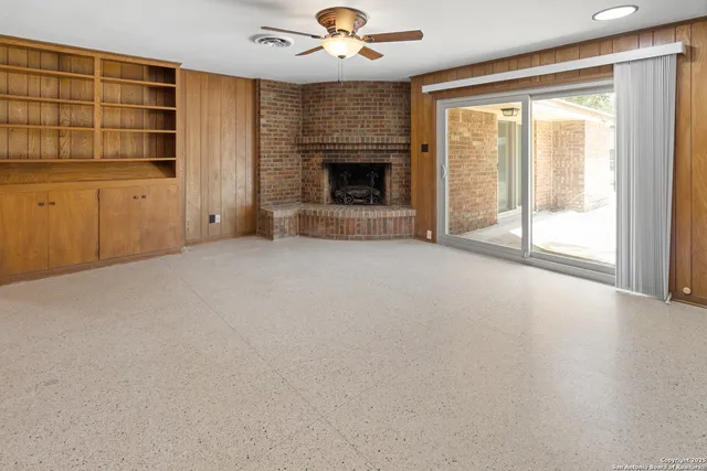 a view of an empty room with a fireplace and a window