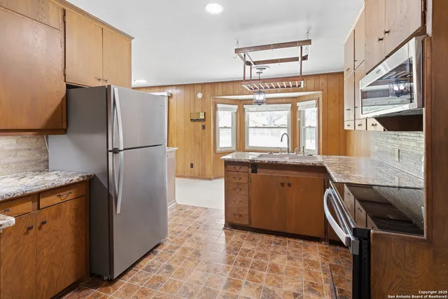 a kitchen with a refrigerator sink and cabinets