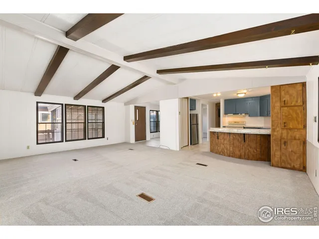 a view of an empty room with a kitchen