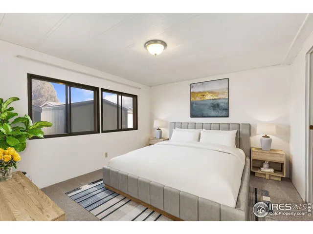 a bedroom with a large bed and a potted plant