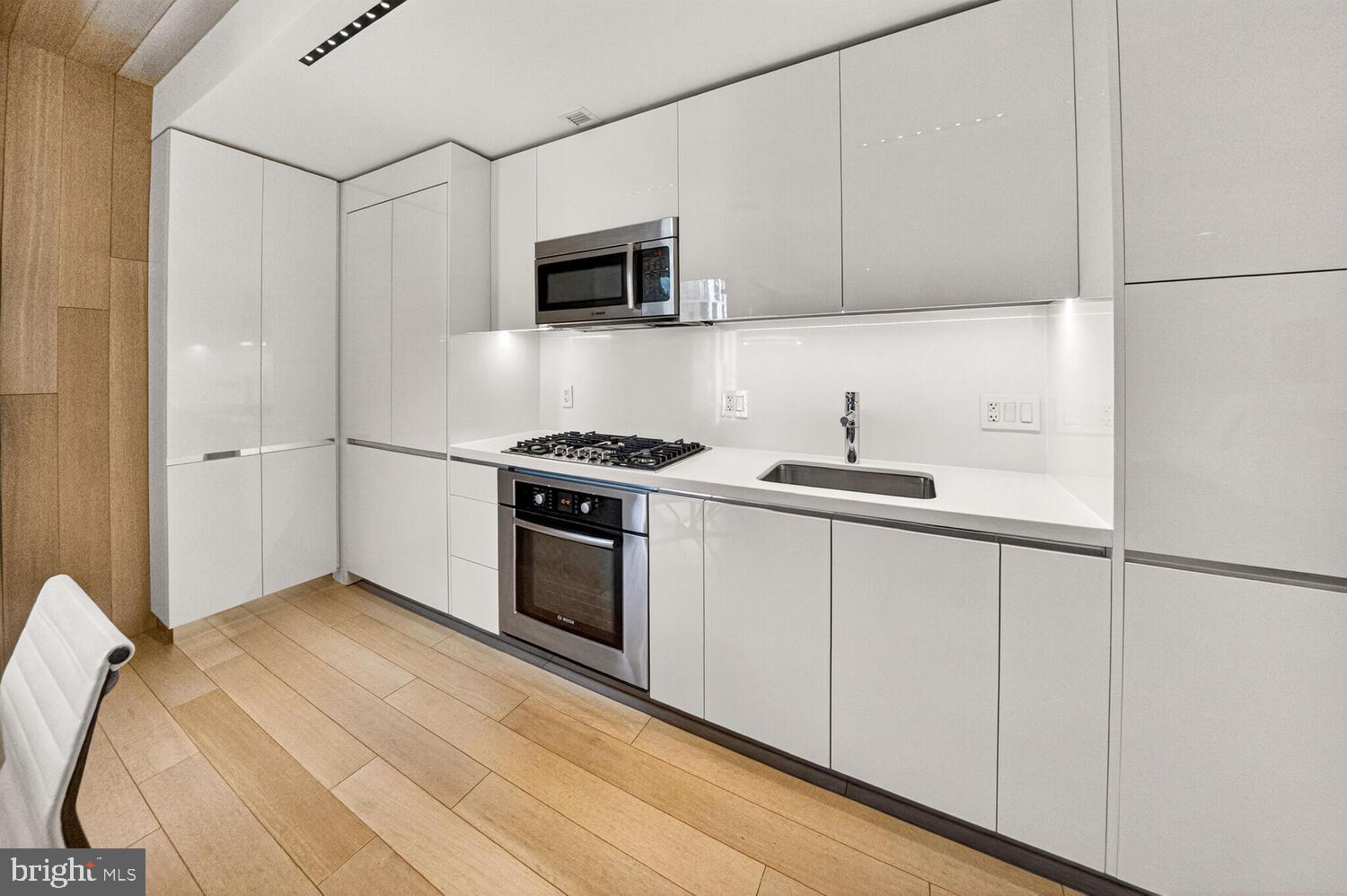 920 I Street Northwest, Unit 704 Washington, DC 20001 - Photo 5 of 24 a kitchen with stainless steel appliances a white stove top oven and sink