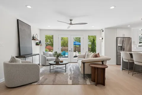 a living room with fireplace furniture and a large window