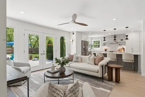 a living room with furniture potted plant and a large window