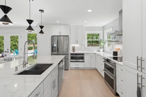 a kitchen with granite countertop a sink stainless steel appliances and counter space