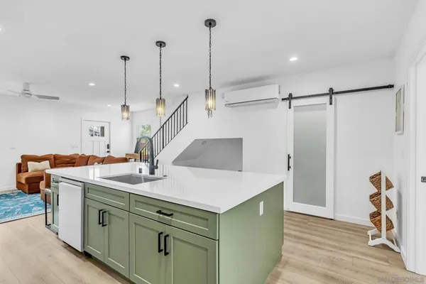 a kitchen with kitchen island a sink a counter and chairs