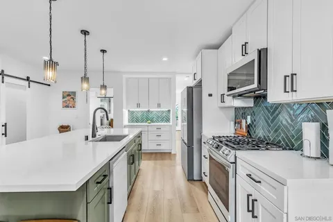 a kitchen with stainless steel appliances kitchen island granite countertop a sink stove and refrigerator