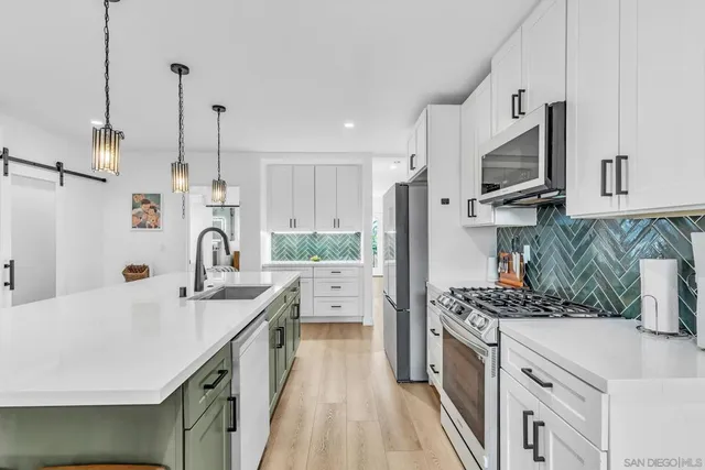 a kitchen with stainless steel appliances kitchen island granite countertop a sink stove and refrigerator