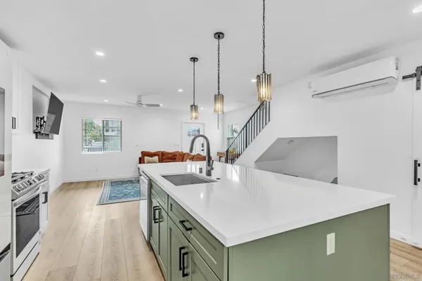 a kitchen with a sink a stove and a wooden floor