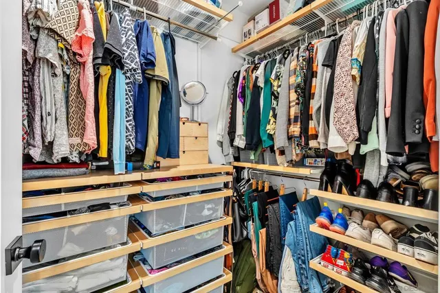 a view of walk in closet with clothes and shoes