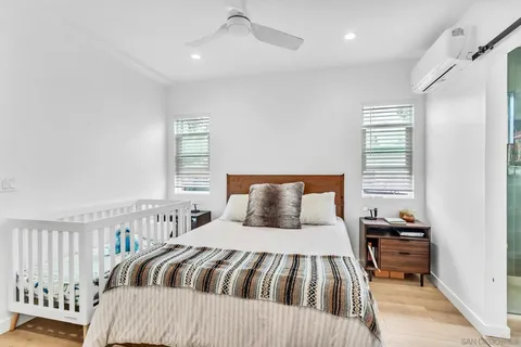a bedroom with a bed and wooden floor