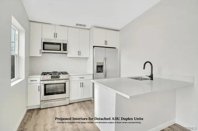 a view of a house with a small yard and wooden floor and fence