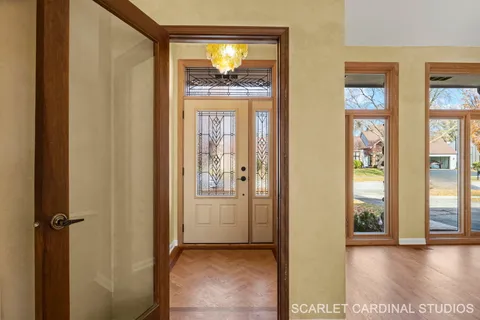 a view of a hallway with wooden floor and windows