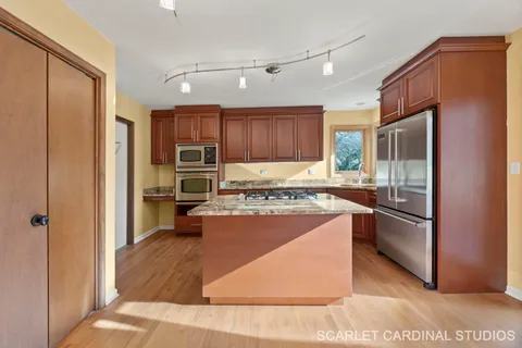 a kitchen with stainless steel appliances granite countertop a refrigerator stove microwave and sink