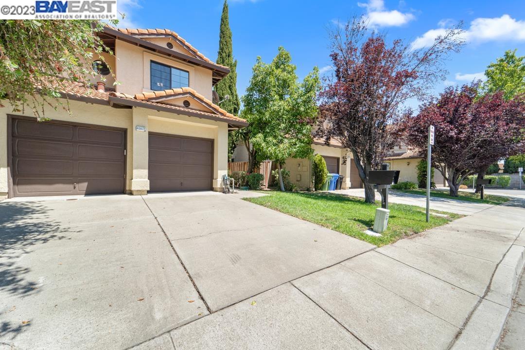a front view of a house with a yard and potted plants