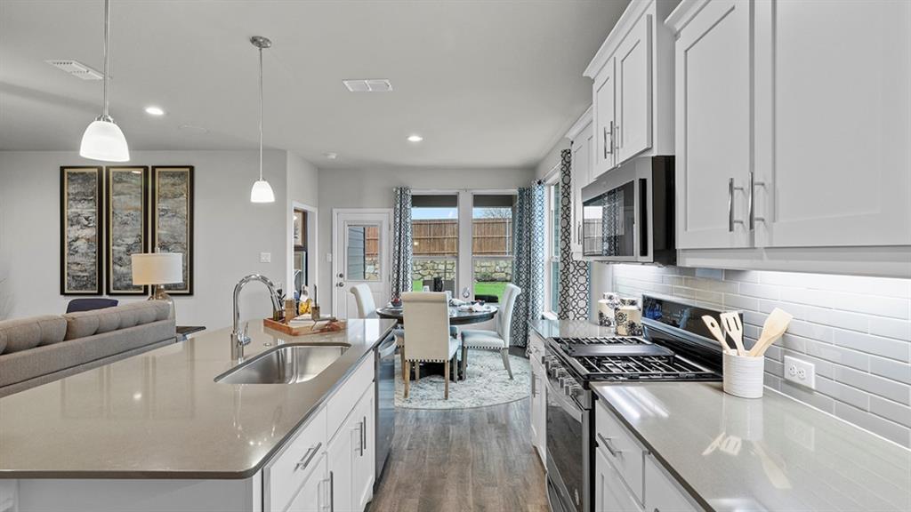 a kitchen with stainless steel appliances granite countertop a sink stove and cabinets