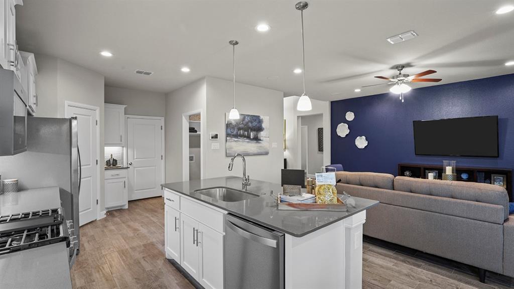 15540 Balham Path Fort Worth, TX 76247 - Photo 3 of 40 a living room with stainless steel appliances kitchen island granite countertop furniture and a flat screen tv