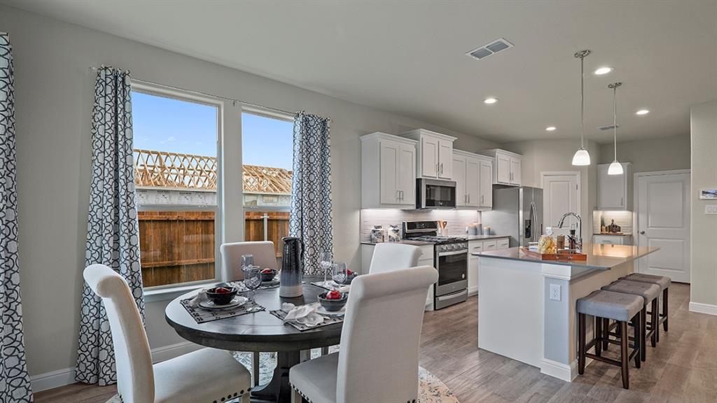 15540 Balham Path Fort Worth, TX 76247 - Photo 8 of 40 a dining room with furniture a large window and kitchen view