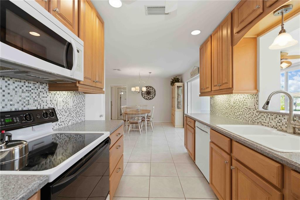 840 Channel Acres Road Nokomis, FL 34275 - Photo 19 of 48 a kitchen with stainless steel appliances granite countertop a sink and a stove