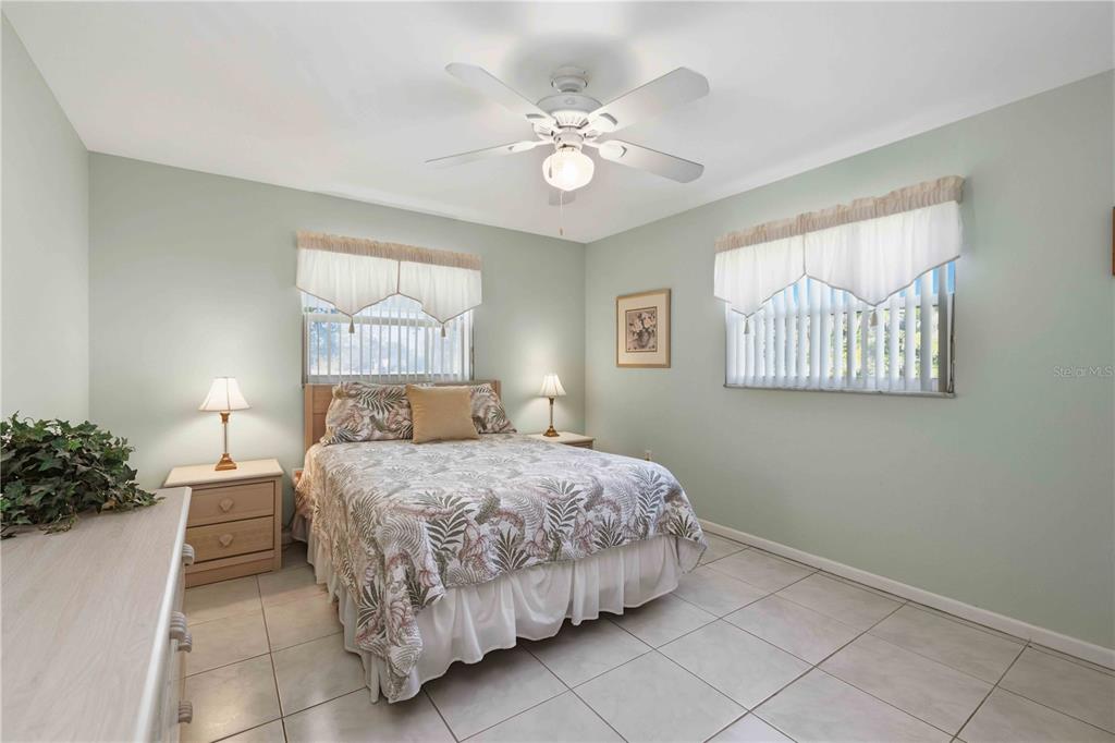 840 Channel Acres Road Nokomis, FL 34275 - Photo 21 of 48 a bedroom with a bed and a chandelier
