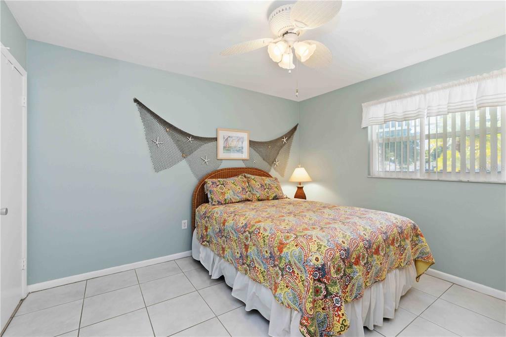 840 Channel Acres Road Nokomis, FL 34275 - Photo 24 of 48 a bedroom with a bed and a chandelier