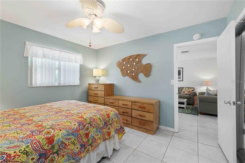 840 Channel Acres Road Nokomis, FL 34275 - Photo 25 of 48 a spacious bedroom with a bed and a chandelier