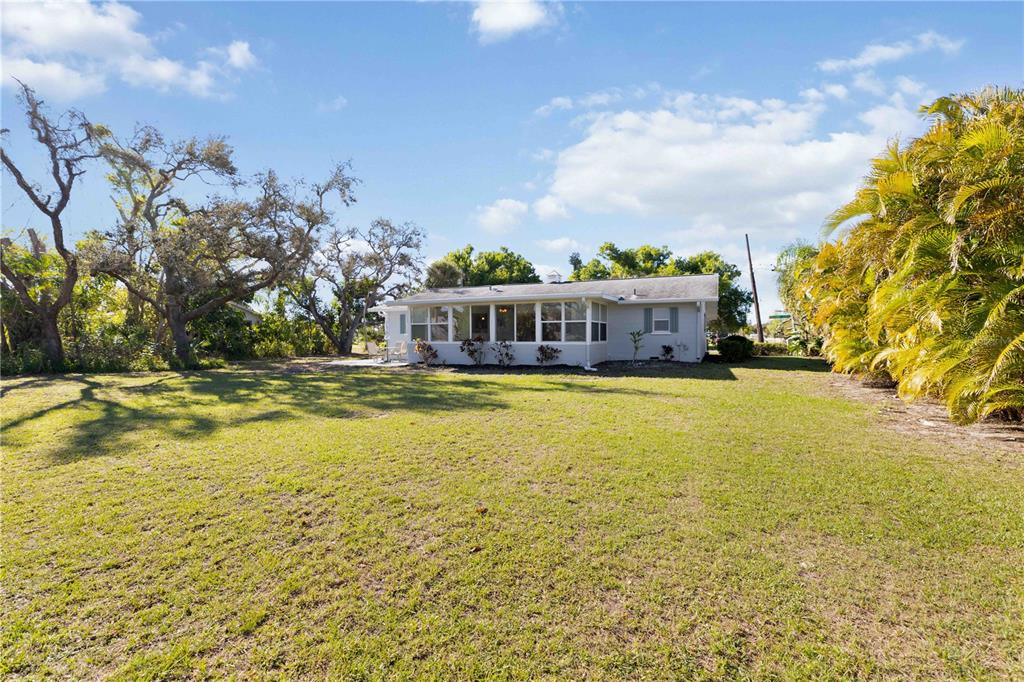 840 Channel Acres Road Nokomis, FL 34275 - Photo 37 of 48 a view of a swimming pool with an outdoor seating and a yard