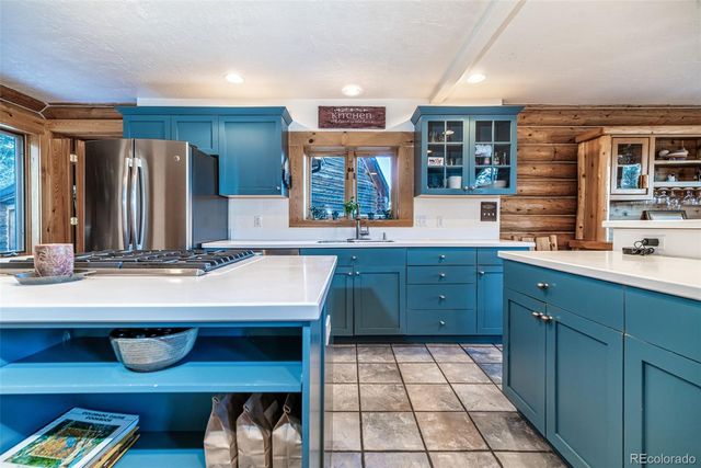 a kitchen with a sink refrigerator and cabinets