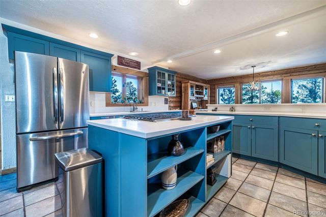 a kitchen with stainless steel appliances granite countertop a refrigerator a sink a stove and a refrigerator