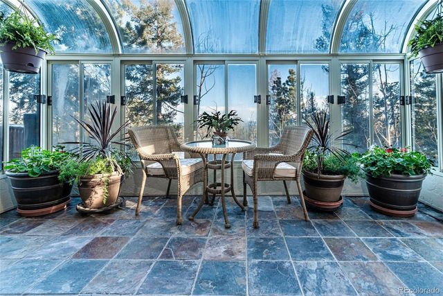 a view of a porch with chairs and potted plants