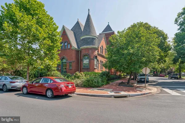 a front view of a house with a garden and parking