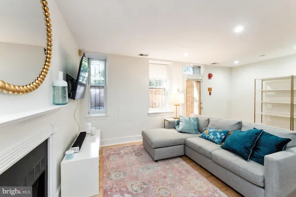 a living room with furniture a fireplace and a flat screen tv
