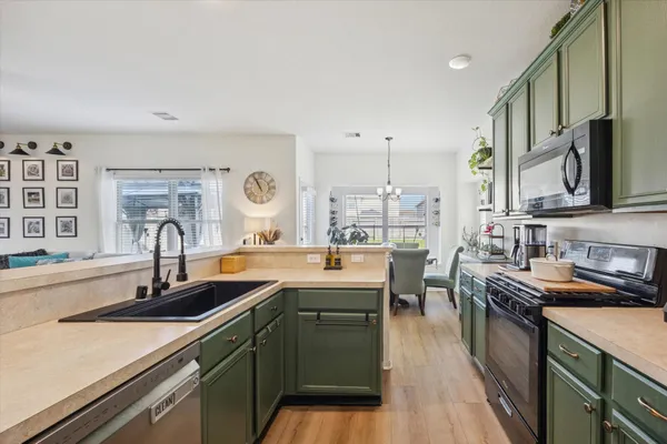 a kitchen with stainless steel appliances granite countertop a sink stove and cabinets