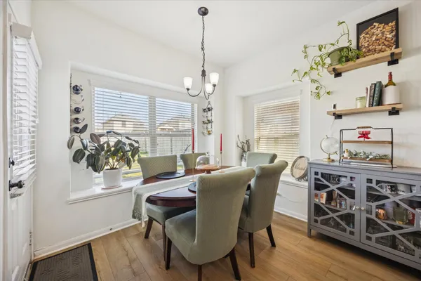 a dining room with furniture a chandelier and wooden floor