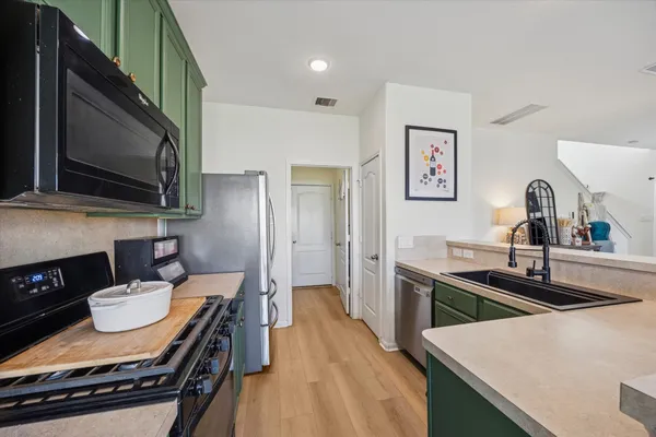 a kitchen with stainless steel appliances a sink stove and refrigerator