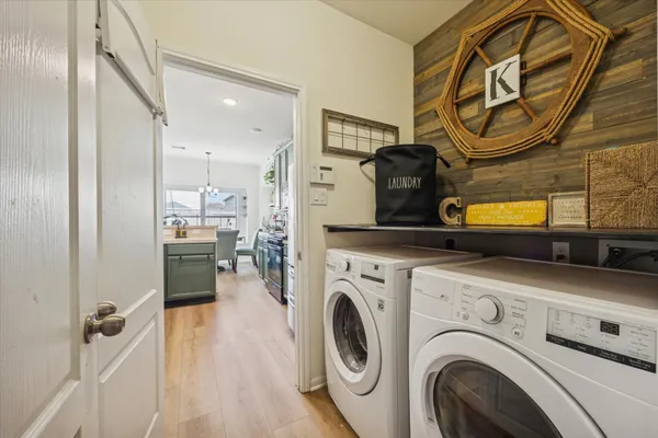 a view of washer and dryer with bathroom in the background