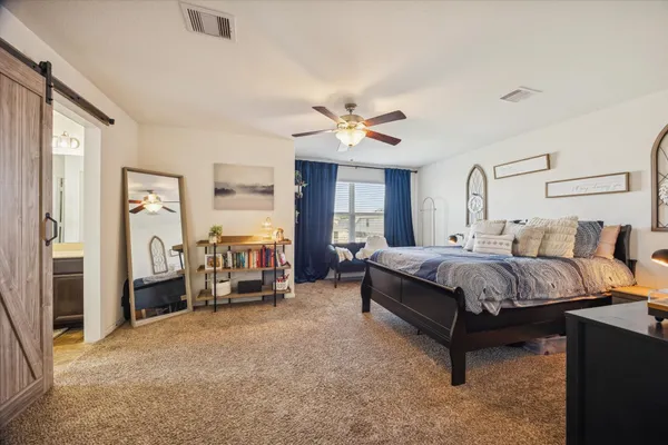 a spacious bedroom with a bed and a chandelier