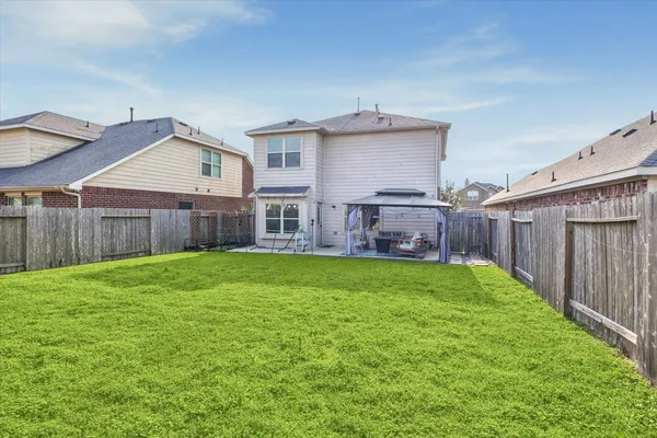 a view of a backyard with table and chairs and wooden fence