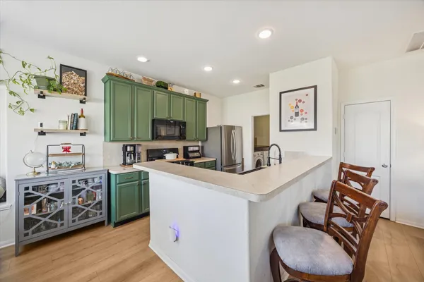 a kitchen with stainless steel appliances a microwave a stove and a refrigerator