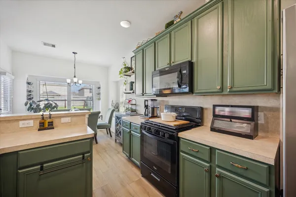 a kitchen with stainless steel appliances a stove a sink and a microwave