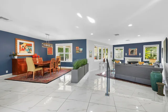 a bedroom with a bed a potted plant on dresser and a window