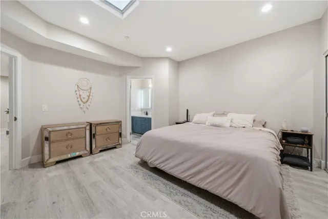 a spacious bedroom with a bed and a dresser