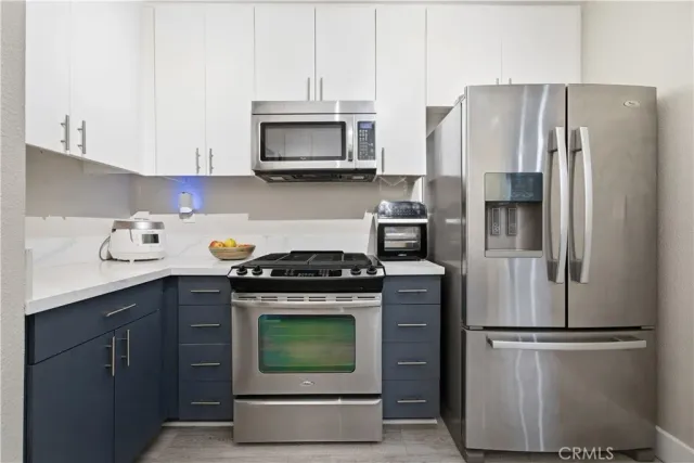 a kitchen with stainless steel appliances a refrigerator stove and microwave