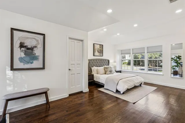 a spacious bedroom with a large bed and a large window