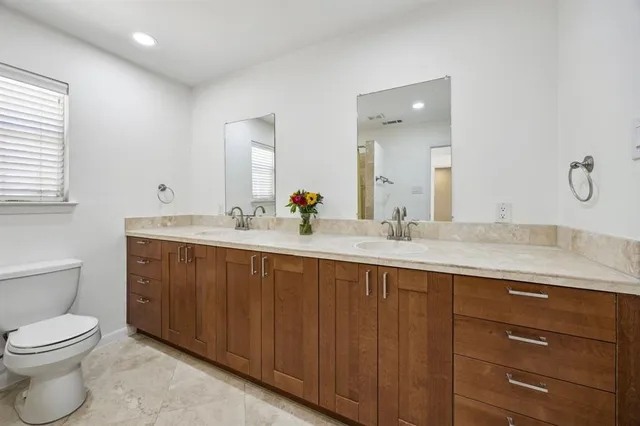 a bathroom with a granite countertop sink a toilet and a mirror