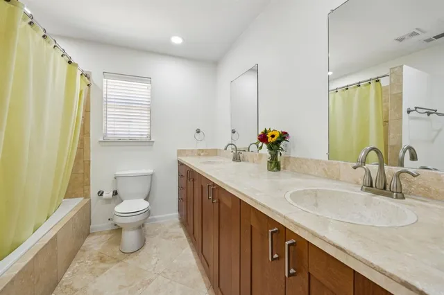 a bathroom with a sink double vanity and a toilet