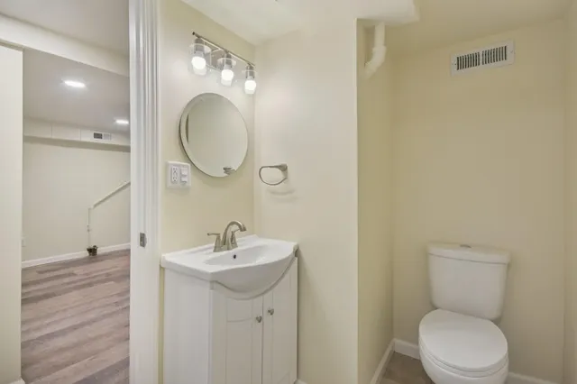 a bathroom with a toilet a sink and mirror
