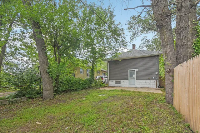 a view of a house with a yard and large tree
