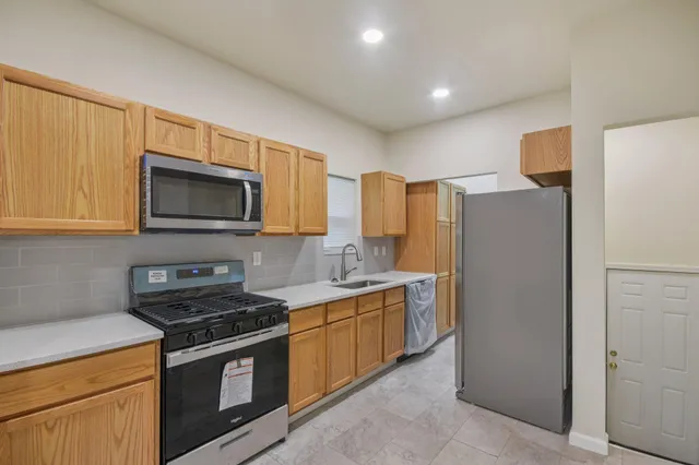 a kitchen with stainless steel appliances granite countertop a refrigerator stove and microwave