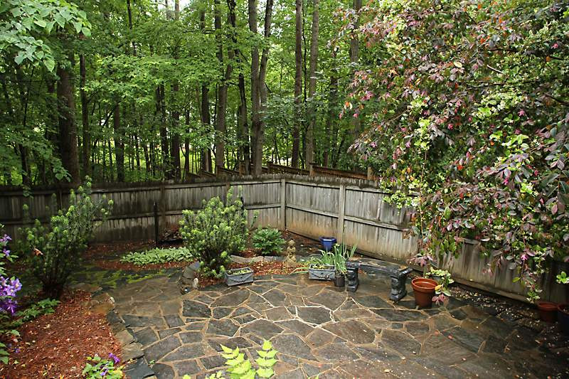 12301 Staunton Court Raleigh, NC 27613 - Photo 21 of 25 Landscaped rock patio surrounded by flower beds and privacy fence from neighbors behind. Patio/Deck